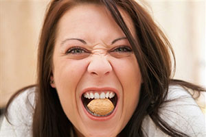 Женщина ест орех