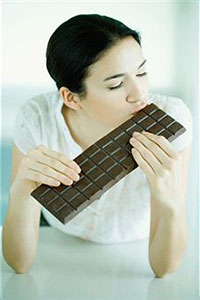 Девушка ест  шоколад