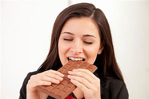 Женщина ест шоколадку