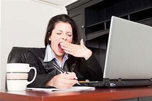 Женщина зевает на работе