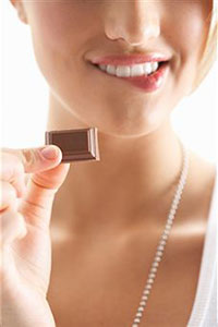 Девушка кусает шоколад