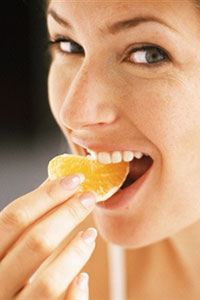 Девушка ест апельсин