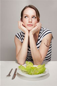 Девушка сидит перед салатом