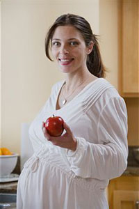 Беременная женщина с яблоком