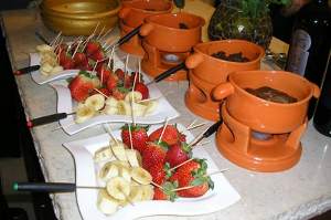 Сладкое фондю с кусочками банана и клубники