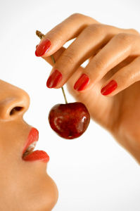 Спелая вишня у женских губ