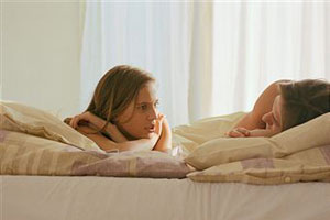 Женщина и мужчина разговаривают в постеле