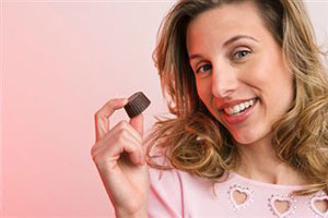 Женщина держит шоколадную конфету