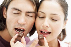 Девушка и мужчина едят шоколад