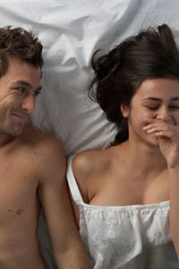 Женщина и мужчина смеются в постеле