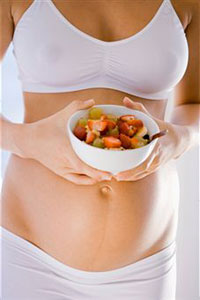 Беременная женщина ест фрукты