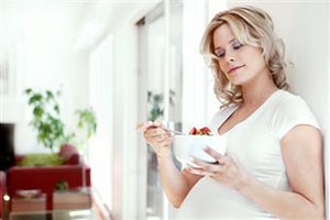 Беременная женщина ест творог