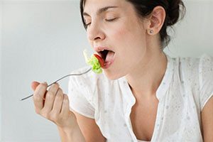 Девушка ест вилкой салат