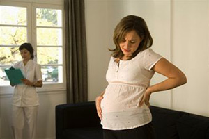 Беременная девушка держится за живот от боли