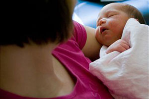 Женщина держит новорожденного на руках