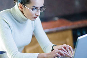 Девушка работает за компьютером в очках