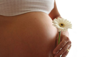 Беременная женщина держит цветок