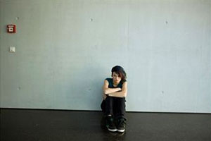Девушка сидит на полу возле стены