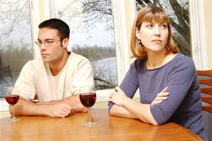 Супруги сидят за столом в ссоре