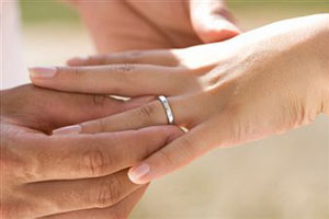 Жених надевает обручальное кольцо невесте