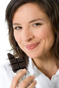 Девушка ест шоколад