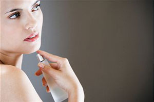 Женщина пользуется парфюмом