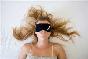 Женщина спит в маске