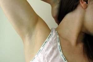 Женщина длеает эпиляцию подмышек воском