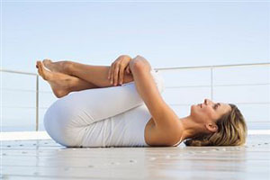 Женщина лежит на спине и тренирует мышцы влагалища