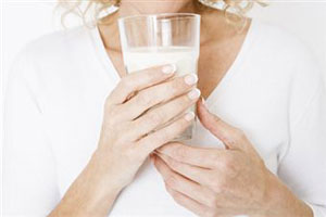 Девушка пьет держит в руках стакан молока