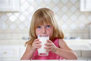 Девочка пьет стакан молока