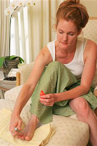 Девушка делает педикюр дома